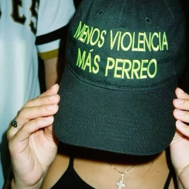 mujer con gorra pidiendo más perreo en la discoteca