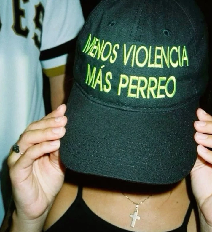 mujer con gorra pidiendo más perreo en la discoteca